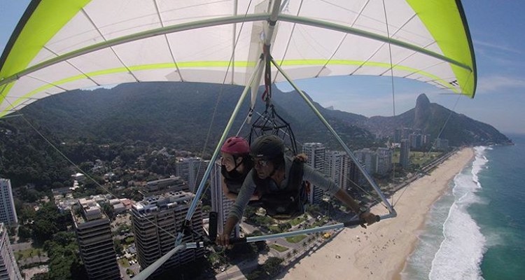 two people paragliding over a beach